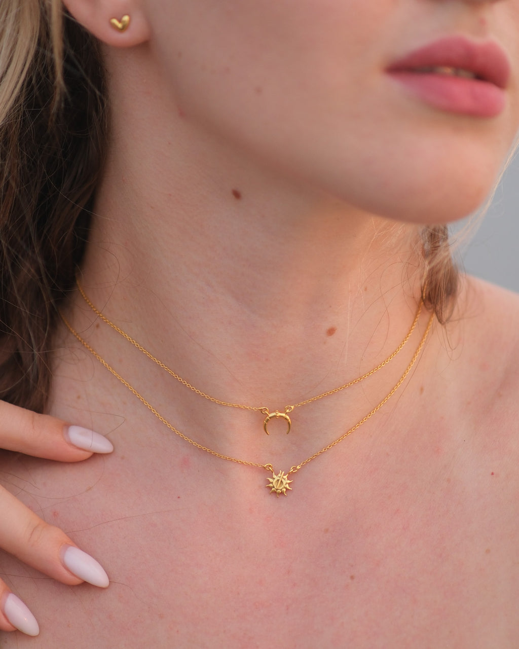 Close-up of hypoallergenic 18KT gold vermeil moon and sun pendant necklace with lobster claw clasp.
