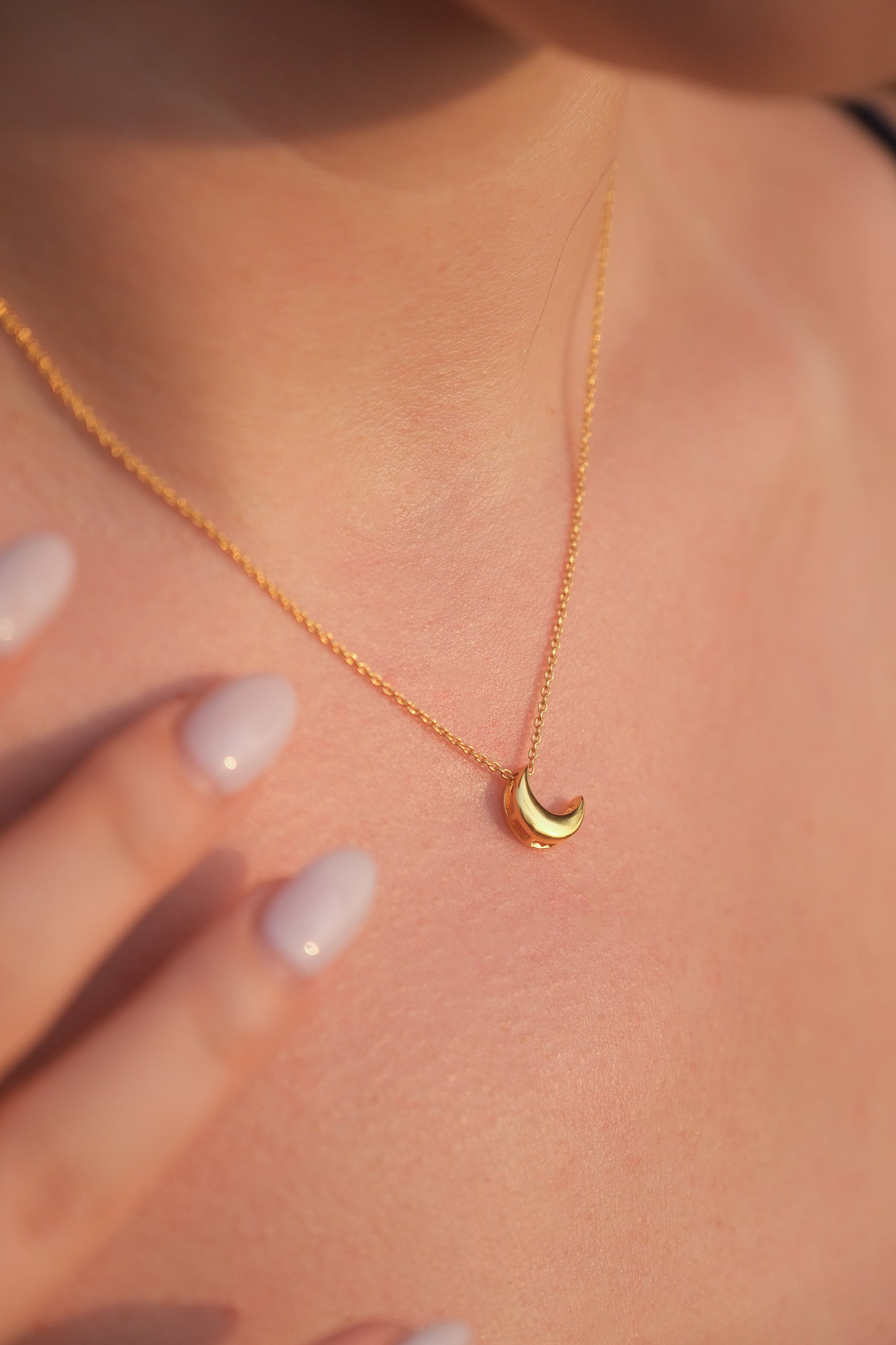 Gold necklace with a small 18KT gold vermeil crescent moon pendant on an adjustable chain