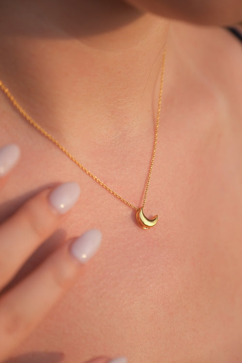 Gold necklace with a small 18KT gold vermeil crescent moon pendant on an adjustable chain