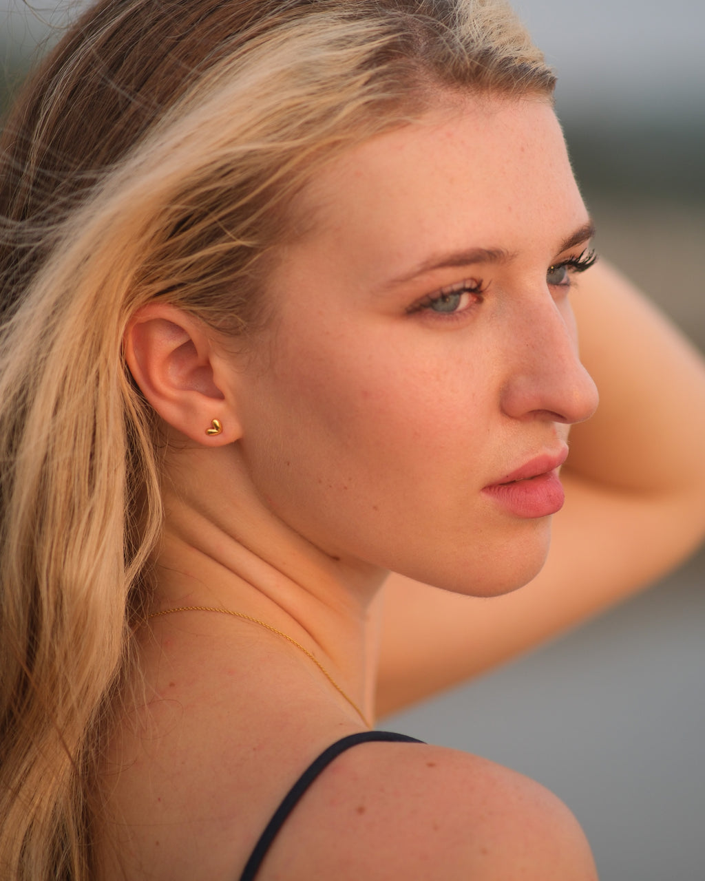 Discover how these dainty 18KT gold vermeil heart stud earrings enhance your look with a subtle, elegant touch. Perfect for everyday wear and special occasions.